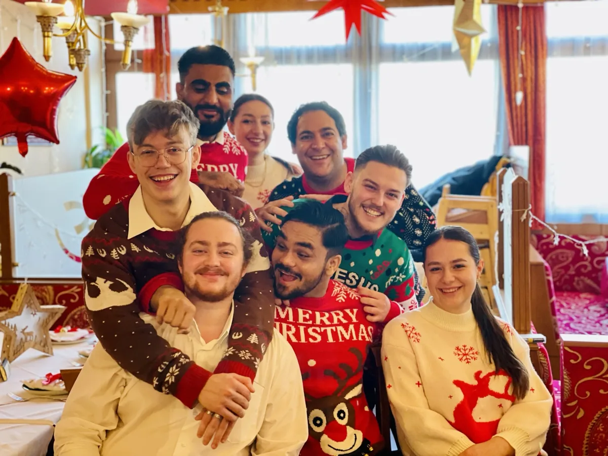 Das Rama-Team in weihnachtlichen Pullovern im Restaurant
